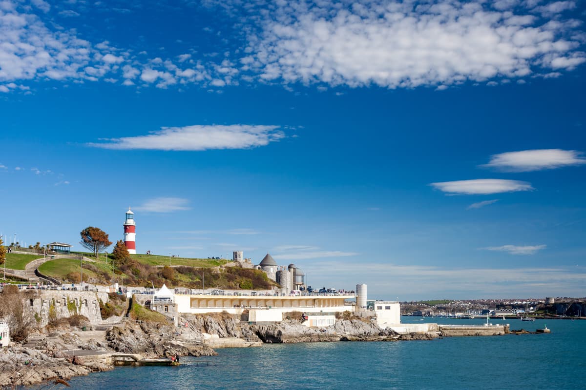 Plymouth coastline with a lighthouse and waterfront buildings